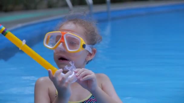 Portrét malé holčičky v podvodní masce plovoucí ve venkovním bazénu. Aktivní odpočinek v aquaparku. Happy Kid.Child připravuje k ponoření do moře — Stock video