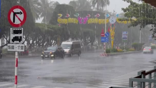 Машини і люди на мотоциклах під час сильного дощу або тропічної зливи переїжджають по асфальтній дорозі в місто Азія, Нха Транг, В "єтнам, 12 серпня 2020 року., — стокове відео