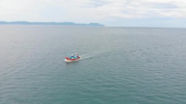 Profesyonel balıkçı teknesi, balık tuttuktan sonra sabah gün ışığında limana döner. Yüksek hızda mürekkep balığı ve ıstakoz avlamak için yengeç tuzakları olan bir balıkçı teknesinin insansız hava aracından ateş eder.