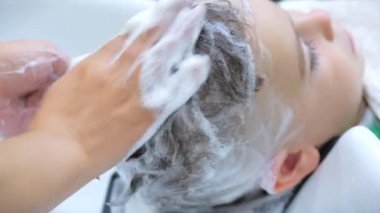 Parekhmacher, anaokulu çağındaki bir çocuğun saçını kestikten sonra saçlarını yıka, şampuanla sabunla yıka, çocukların saçlarını kestikten sonra dinlenip keyif almalarını sağla.