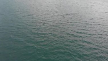 İHA yüksek hızda deniz veya deniz dalgalarını vurarak ateş ediyor. Seyahat konsepti, ileri uçuş.