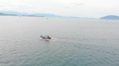 Profesyonel balıkçı teknesi, balık tuttuktan sonra sabah gün ışığında limana döner. Yüksek hızda mürekkep balığı ve ıstakoz avlamak için yengeç tuzakları olan bir balıkçı teknesinin insansız hava aracından ateş eder.