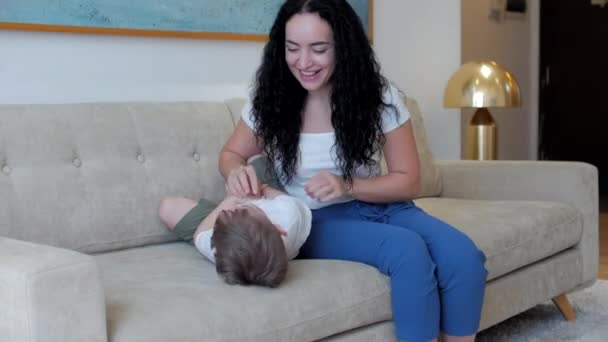 Conceito do dia das mulheres. A mãe tem um relacionamento amoroso terno.Conceito de uma família feliz. Menino-filho abraça sua amada mãe com as mãos beija-la na bochecha. Filho brincando com a mãe. — Vídeo de Stock