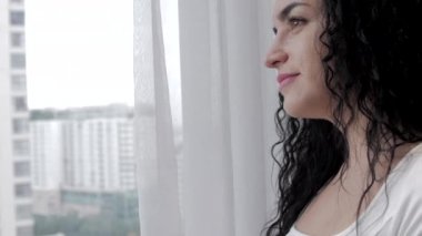 Mutfakta çay içen tatmin olmuş bir kadının portresi. Çekici bayan evde ağır çekimde bir fincan kahveden zevk alıyor. Sabahları elinde çay tutan gülümseyen bir kadın.