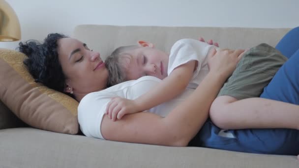 Conceptul zilei femeii. Mama are o relație tandră afectuoasă cu fiul ei mai mic. Conceptul de familie fericit. Fiul cel mic doarme întins pe mama lui, îmbrățișat mama lui iubită . — Videoclip de stoc