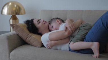 Kadınlar günü konsepti. Annemin küçük oğluyla şefkatli bir ilişkisi var. Küçük oğlu, sevgili annesine elleriyle sarılıyor ve onu yanağından öpüyor. Çocuk oyun oynuyor. Annesi kim?.