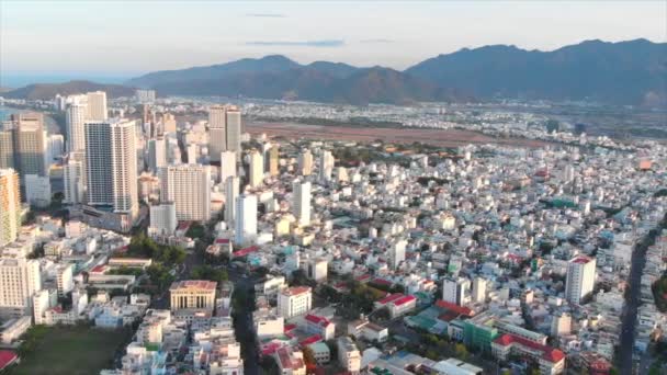 Drones luchtfoto 's nemen een prachtig uitzicht op de grote stad vanuit een vogelperspectief met wolkenkrabbers of hoge gebouwen tegen de achtergrond van een prachtige blauwe zee. 4K. — Stockvideo