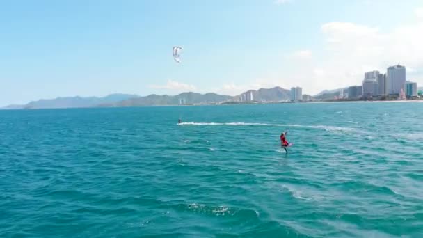 专业风筝冲浪者在海浪上的杂技跳跃，运动员在空中用风筝和滑板表演体育特技跳跃。极端水上运动和暑假概念 — 图库视频影像