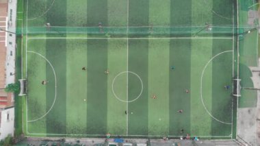 Futbol maçından önce antrenmana başla. Oyun süreci. Küçük bir futbol sahasının havadan çekilmiş görüntüsü, dışarıda futbol oynayan iki takım, üst manzara. İşaretli yeşil alan, topla koşan oyuncular