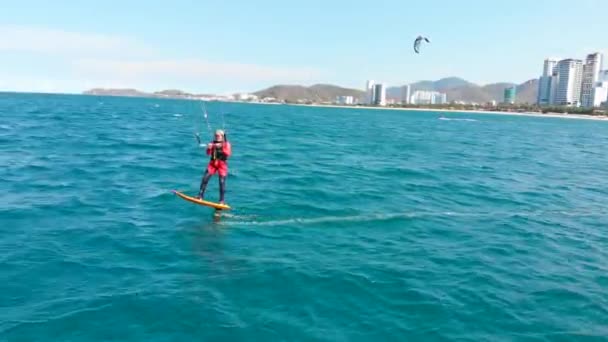 极端水上运动和暑假的概念。专业的冲浪运动员在海浪上冲浪，运动员在空中用风筝和滑板表演体育特技表演. — 图库视频影像