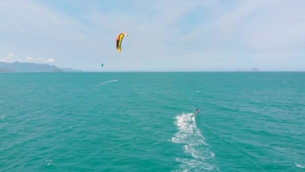 Acrobatische sprong van professionele kitesurfer op de zee golf, atleet tonen sport truc springen met vlieger en boord in de lucht. Extreme watersport en zomervakantie concept — Stockvideo