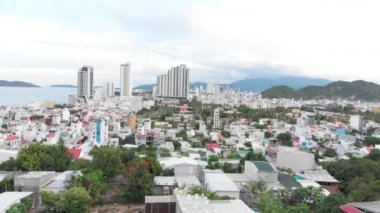 İnsansız hava araçları, güzel mavi bir denizin arka planına karşı gökdelenleri ya da yüksek binaları olan kuş bakışı bir manzarayla büyük şehri güzel bir şekilde görürler. 4K.