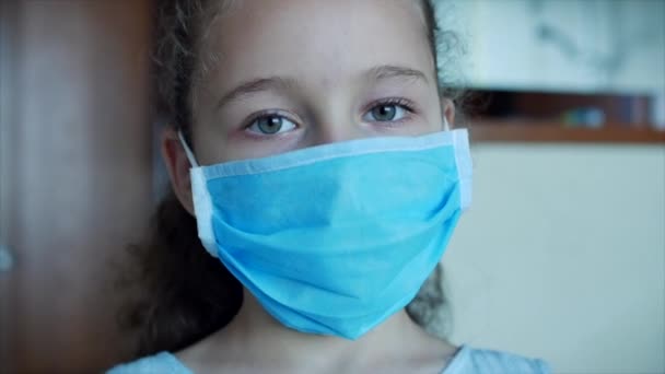 Retrato lindo niño pequeño o niña en una máscara médica protectora, con una triste cara decepcionada. Chica con máscara médica. Pandemia, covidio - 19. — Vídeo de stock