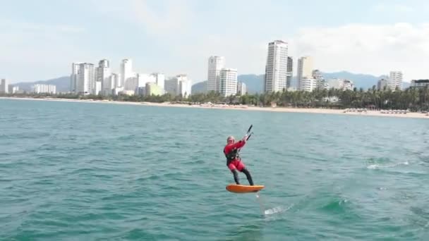 专业的冲浪运动员在海浪上冲浪，运动员在空中用风筝和滑板表演体育特技表演。极端水上运动和暑假概念 — 图库视频影像