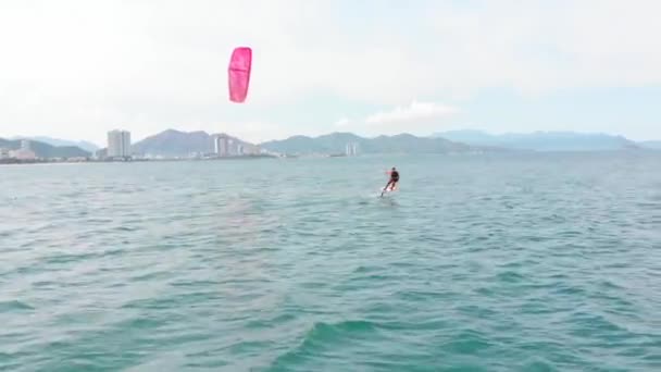 Vlieger surfplaats, sportconcept, gezonde levensstijl, menselijke vlucht. Luchtfoto van het stadsstrand en actieve mensen die kitesurfen en windsurfen beoefenen. — Stockvideo
