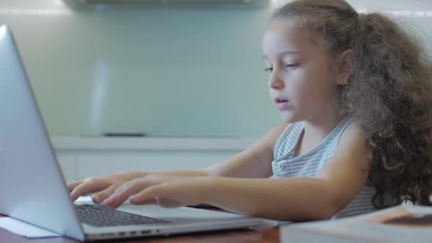 Kislány egy aranyos általános iskolás gyermek 7-8 éves otthon tanul a családi tanulás hallgatja iskolai előadások házi feladatot anélkül, hogy elhagyná otthon.Gyermek otthon tanulás, gyerekek oktatási koncepció — Stock videók