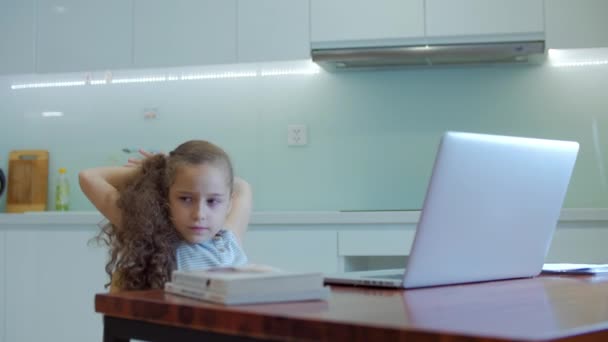Fáradt kislány egy aranyos általános iskolás gyermek 7-8 éves otthon tanul a családi tanulás hallgatja iskolai előadások házi feladatot anélkül, hogy elhagyná otthon.Gyermek otthon, gyerekek oktatás — Stock videók