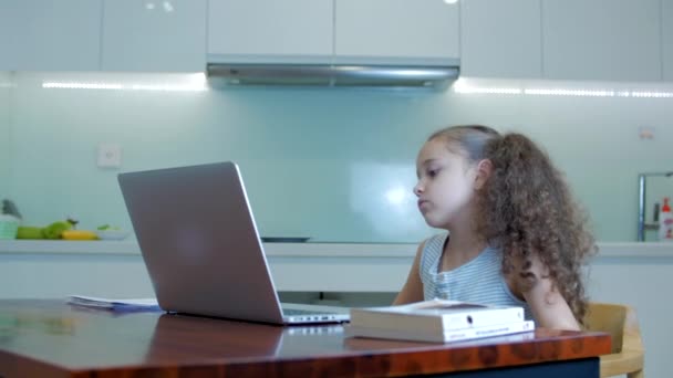 Niña cansada una linda niña de la escuela primaria de 7-8 años en casa estudiando en el aprendizaje familiar escucha las conferencias escolares hace la tarea sin salir de casa.Educación en el hogar de los niños, la educación de los niños — Vídeos de Stock