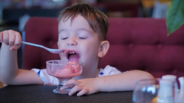 Portrait Cute Little Boy disfruta de un delicioso helado en el cono de gofres durante el verano. Niño con helado con chocolate y cereza en casa. Chico divertido comiendo helado.. — Vídeo de stock