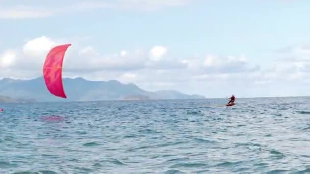 Atleta mostrando truque esporte pulando com pipa e bordo no ar. Esportes aquáticos extremos e conceito de férias de verão. Salto acrobático de kite surfista profissional na onda do mar — Vídeo de Stock
