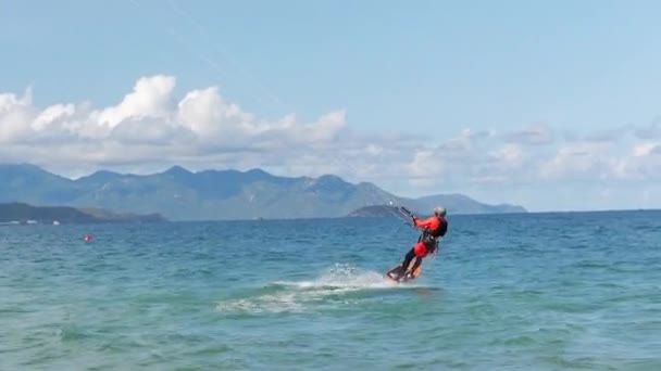 运动员在空中用风筝和跳板表演体育特技表演.极端水上运动和暑假的概念。专业风筝冲浪者在海浪上的杂技跳跃 — 图库视频影像