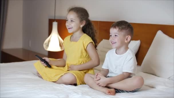 Portrait cute Little Kids While Watching TV on Laptop. Boy and Girl Watch Cartoon on Laptop on Living Room. Concept Video Game, Entertainment, Emotions, Family. Children Brother and Sister Watching TV — Stock Video