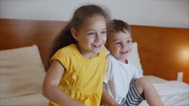Laptop 'ta TV izlerken şirin çocuklar. Erkek ve Kız İzleme çizgi filmi oturma odasında dizüstü bilgisayarda. Konsept Video Oyunu, Eğlence, Duygular, Aile. Çocuklar Erkek ve Kız Kardeş TV izliyor