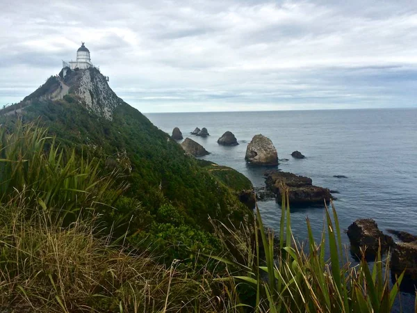 灯塔俯瞰着新西兰南部海滩上岩石崎岖的海岸线 — 图库照片