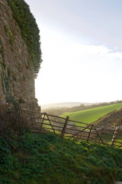 Kale, yeşil tarım alanları büyük kaya duvarın arkasında güneş ayarı