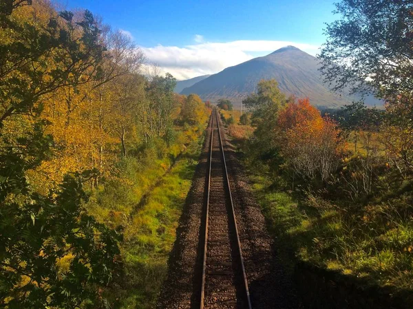 田舎を通る鉄道線路 スコットランドの高地を背景に山々 秋の午後 — ストック写真