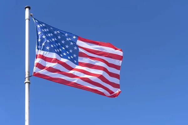 American Flag waving against blue Sky, USA Flag waving as Background