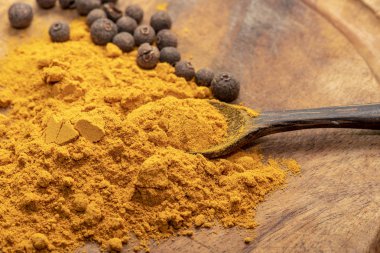 Hint Zerdeçal veya Curcuma Biber ve Kaşık ahşap masa üzerinde 