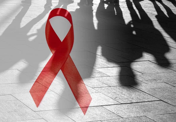 Shadows of People and Red Ribbon as Symbol of Hope - Hiv Aids conceptual Picture about situation in the World
