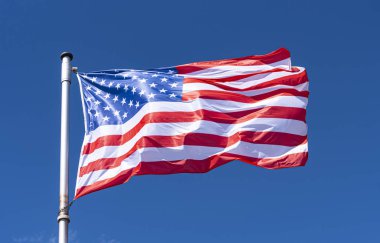 Arka Plan olarak ABD Bayrağı ve mavi Gökyüzü, bayrak direğinde sallanan Amerikan Bayrağı, New York