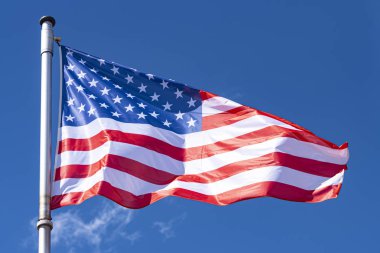 Arka Plan olarak ABD Bayrağı ve mavi Gökyüzü, bayrak direğinde sallanan Amerikan Bayrağı, New York