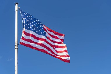 Arka Plan olarak ABD Bayrağı ve mavi Gökyüzü, bayrak direğinde sallanan Amerikan Bayrağı, New York