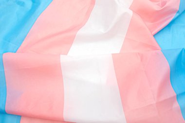 Beyaz, pembe, mavi şeritli transseksüel kumaş bayrağı. Arka plan veya doku olarak transseksüel gurur bayrağını kapat