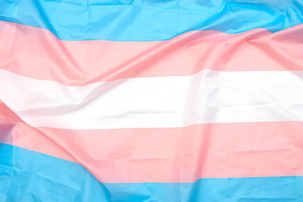 Beyaz, pembe, mavi şeritli transseksüel kumaş bayrağı. Arka plan veya doku olarak transseksüel gurur bayrağını kapat