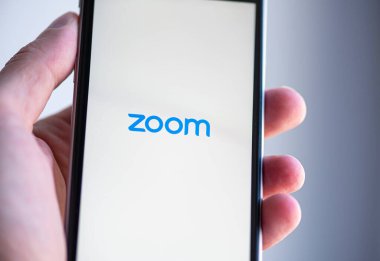 22 Haziran: 22 Haziran 'da Berlin' de ekranda ZOM uygulamasının logosu olan cep telefonu tutan adam görülüyor. Almanya 'da 2020