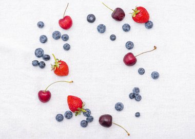 Böğürtlenli yaz seti: kiraz, çilek, yabanmersini ya da böğürtlen ve böğürtlen tekstil arka planda, üst görünüm