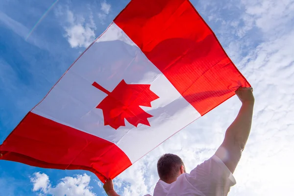 Άντρας Την Εθνική Σημαία Του Καναδά Ενάντια Στον Γαλάζιο Ουρανό — Φωτογραφία Αρχείου