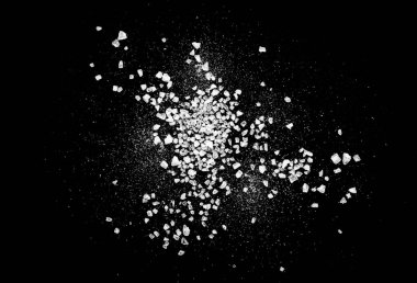 Siyah zemin üzerinde izole edilmiş deniz tuzu ya da kaba tuz kristallerinin yakın plan görüntüsü