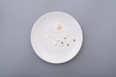 Kırıntılı beyaz tabak ve krema üstüne tatlı pasta, üst manzara.