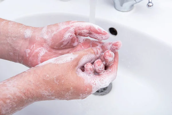 Man washing his hands by soap with foam, concept picture about virus and hygiene