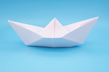 Su olarak mavi arkaplan yüzeyinde kağıt gemi origamisi