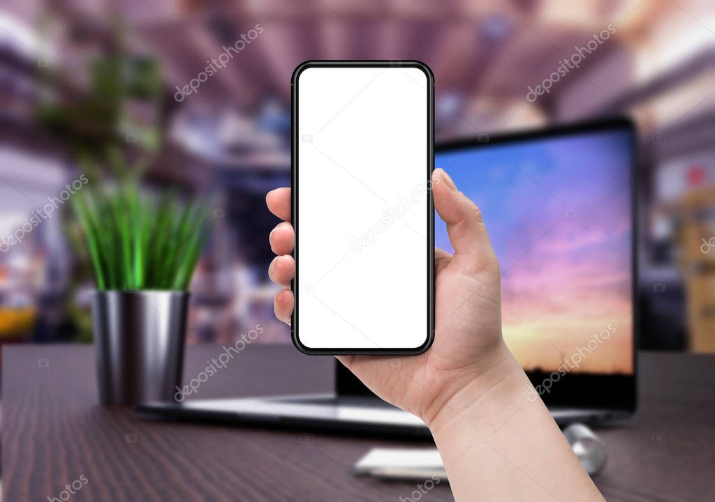 Woman holding smartphone with blank screen.