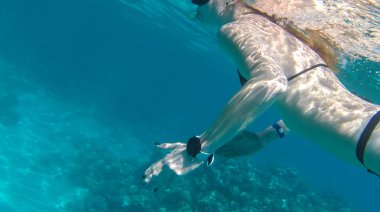 Coral red Sea'deki/daki yakınındaki kız yüzüyor.