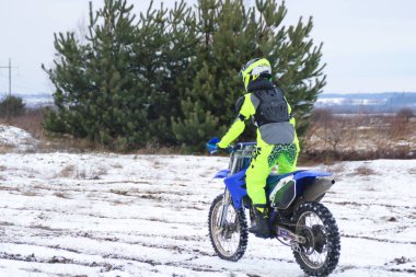 Bir adam bir çapraz-motosiklet trenlerde kar kış.