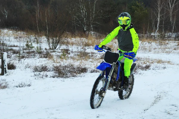 Bir adam bir çapraz-motosiklet trenlerde kar kış.