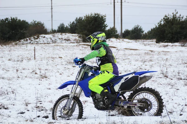 Bir adam bir çapraz-motosiklet trenlerde kar kış.
